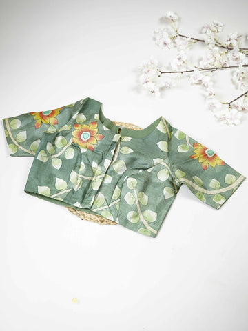 Tussar This elegant leaf green Tussar blouse features finely stitched hand-painted Pen Kalamkari floral designs. The intricate artwork reflects traditional craftsmanship with beautiful artistic detailing. The fresh leaf green shade enhances the painted flowers, giving it a natural and graceful appeal. Perfect for ethnic wear, it creates a stylish and uniquely handcrafted traditional look. Kamini - Tussar Silk Saree | Hand Embroidered - Manoranjitham Weaves - Handloom Store