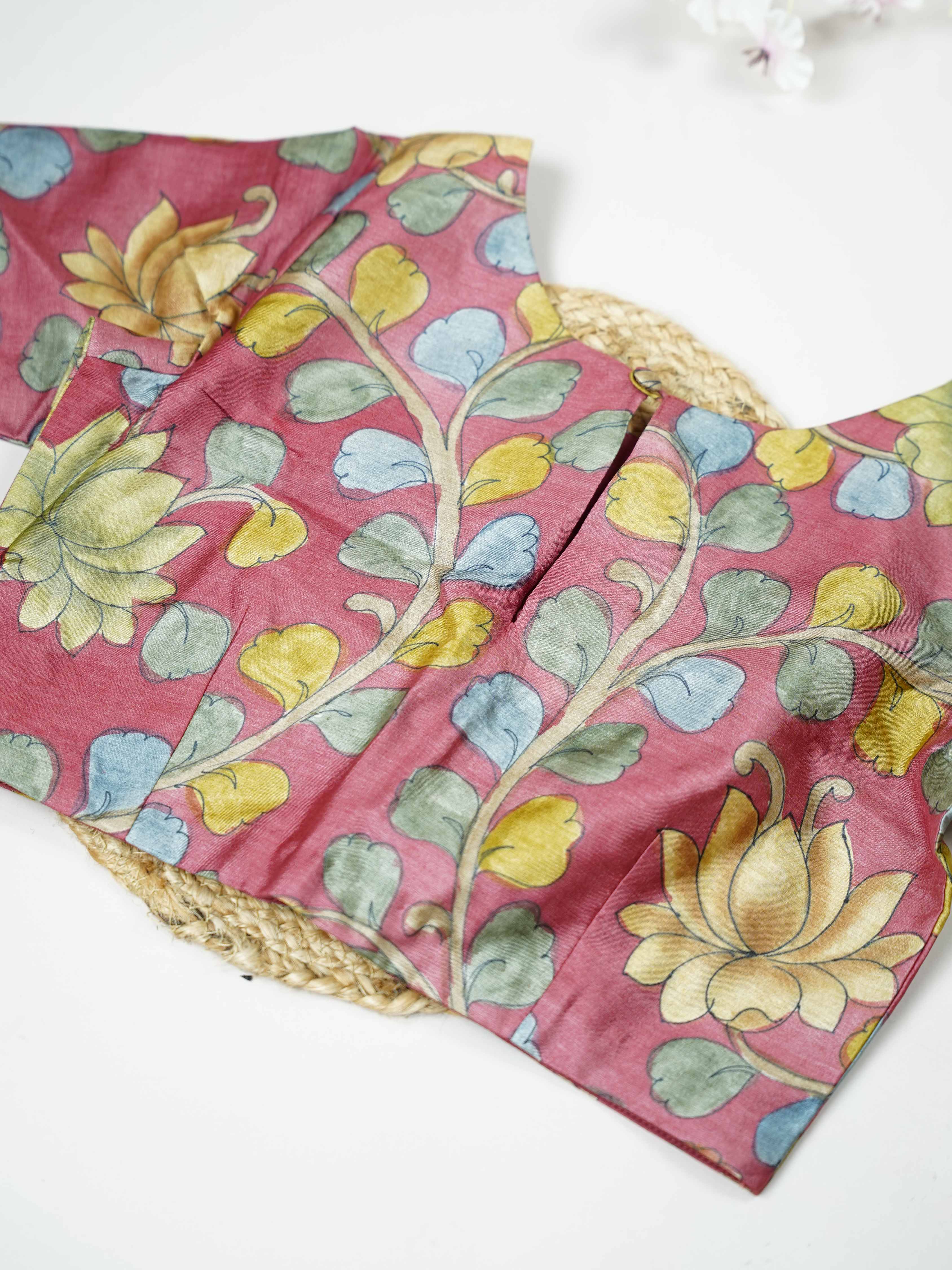 Tussar This elegant pink Tussar blouse features finely stitched hand-painted Pen Kalamkari floral designs. The delicate artwork showcases traditional craftsmanship with graceful and artistic detailing. The soft pink shade enhances the hand-painted flowers, giving it a charming ethnic appeal. Perfect for pairing with sarees, it creates a stylish and beautifully handcrafted traditional look. Kusuma - Tussar Silk Saree | Hand Embroidered - Manoranjitham Weaves - Handloom Store