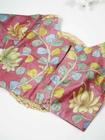 Tussar This elegant pink Tussar blouse features finely stitched hand-painted Pen Kalamkari floral designs. The delicate artwork showcases traditional craftsmanship with graceful and artistic detailing. The soft pink shade enhances the hand-painted flowers, giving it a charming ethnic appeal. Perfect for pairing with sarees, it creates a stylish and beautifully handcrafted traditional look. Kusuma - Tussar Silk Saree | Hand Embroidered - Manoranjitham Weaves - Handloom Store