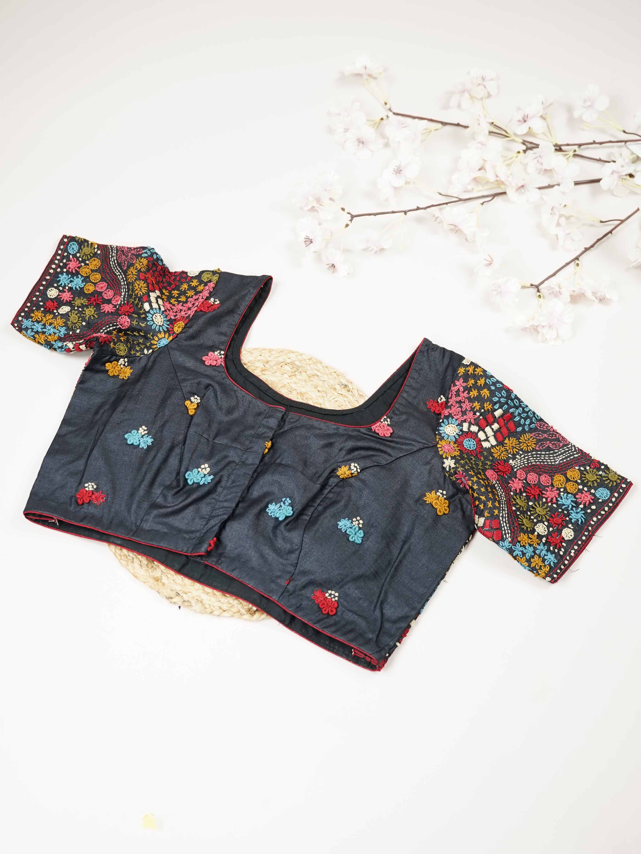 Tussar This elegant black Tussar designer blouse features finely stitched contrast hand Kantha work.br data-start=93 data-end=96The front is adorned with small floral motifs, adding a subtle yet graceful charm.br data-start=178 data-end=181The back is fully detailed with rich Kantha embroidery, showcasing intricate craftsmanship.br data-start=272 data-end=275Perfect for ethnic wear, it creates a bold, stylish, and beautifully balanced traditional look. Alankrita - Tussar Silk Saree | Hand Embroidered - Mano