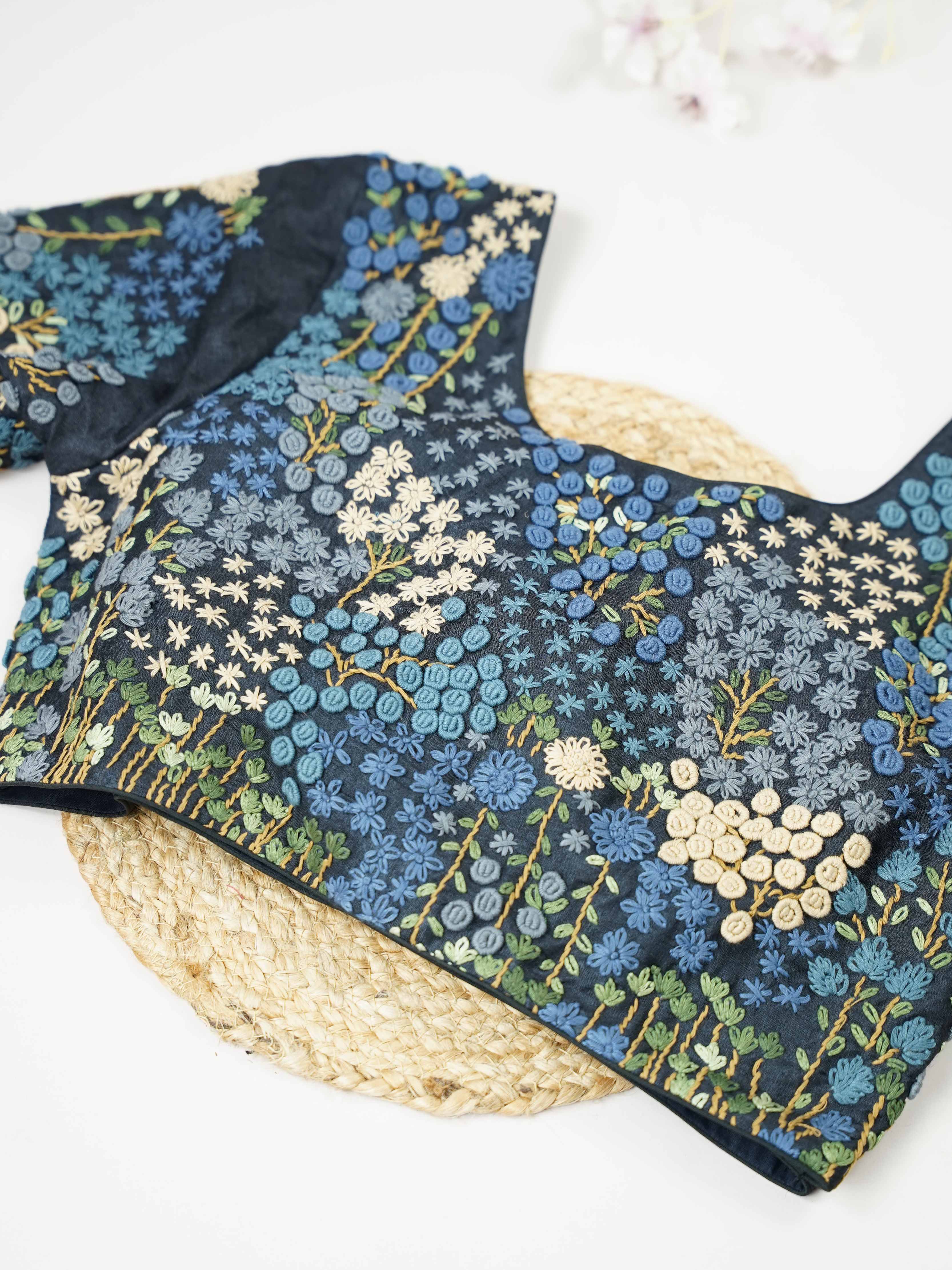 Tussar This elegant black Tussar designer blouse features beautifully stitched contrast hand embroidery work. The front is adorned with small floral motifs, adding a subtle yet graceful charm. The back is richly designed with full embroidery, showcasing intricate craftsmanship.br data-start=275 data-end=278Perfect for ethnic wear, it creates a bold, stylish, and eye-catching traditional look. Avarni - Tussar Silk Saree | Hand Embroidered - Manoranjitham Weaves - Handloom Store