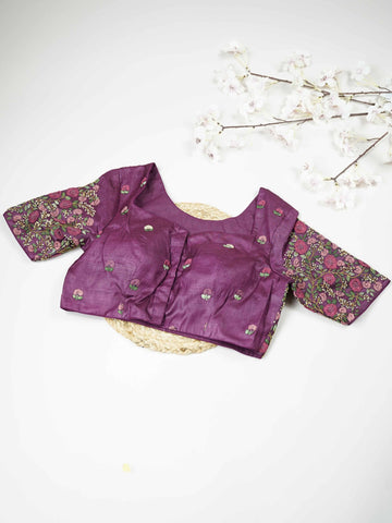 Tussar This elegant wine-coloured Tussar blouse features finely stitched hand embroidery work. The front is delicately designed with small floral motifs, adding a subtle feminine charm. Nyra - Tussar Silk Saree | Hand Embroidered - Manoranjitham Weaves - Handloom Store