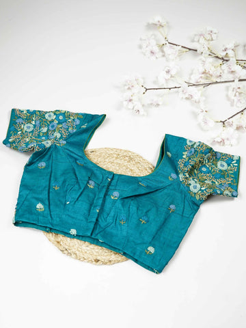 Tussar This elegant peacock blue Tussar designer blouse features finely stitched hand embroidery work. The front is adorned with small floral motifs, adding a delicate and graceful charm.br data-start=182 data-end=185The back is fully detailed with rich embroidery, showcasing intricate craftsmanship.br data-start=269 data-end=272Perfect for ethnic wear, it creates a bold, stylish, and beautifully balanced traditional look. Ira - Tussar Silk Saree | Hand Embroidered - Manoranjitham Weaves - Handloom Store