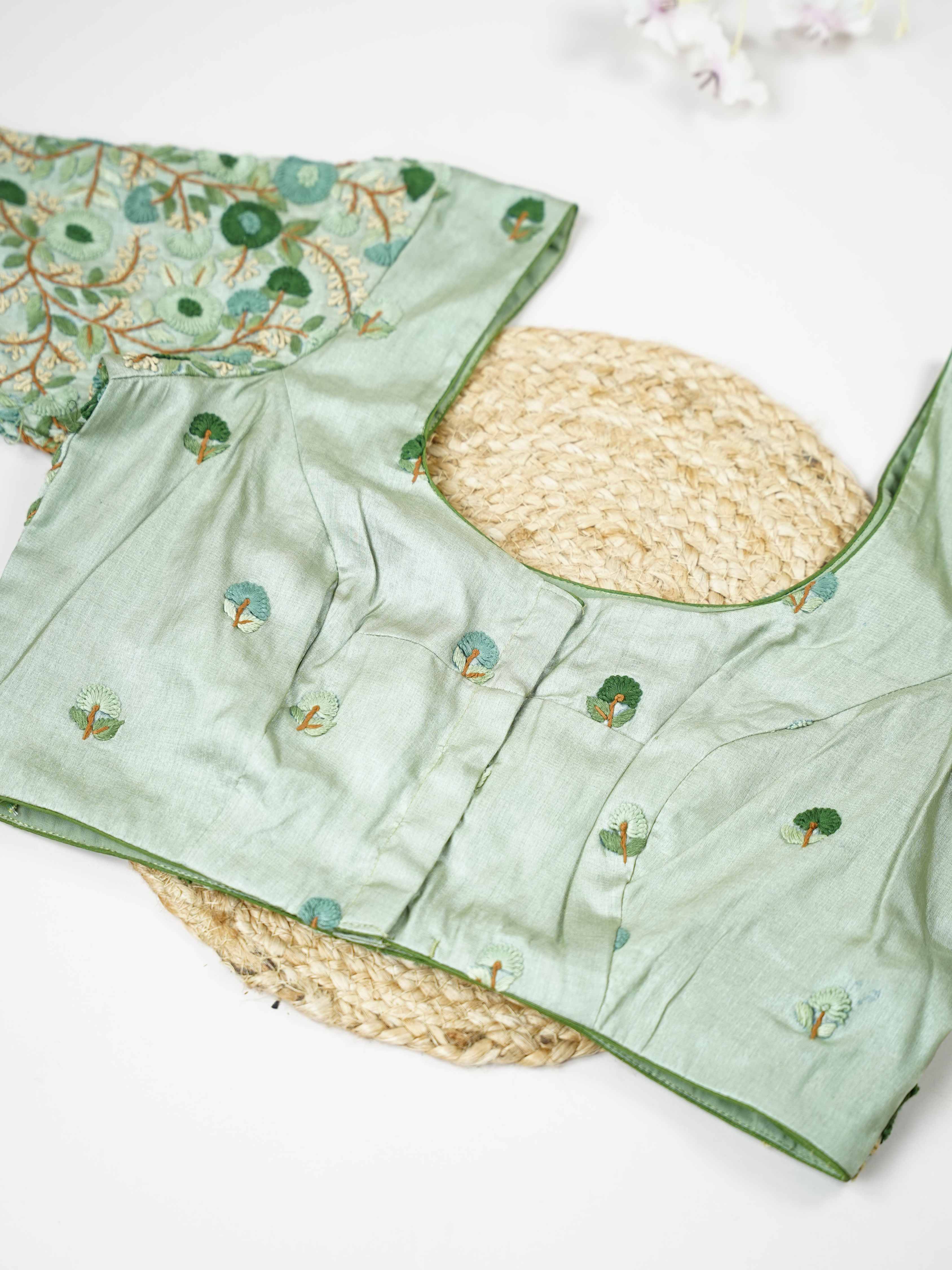 Tussar This elegant mint green Tussar designer blouse features finely stitched hand embroidery work. The front is adorned with small floral motifs, adding a soft and graceful charm.br data-start=176 data-end=179The back is fully detailed with rich embroidery, showcasing intricate craftsmanship.br data-start=263 data-end=266Perfect for ethnic wear, it creates a stylish, refreshing, and beautifully balanced traditional look. Komala - Tussar Silk Saree | Hand Embroidered - Manoranjitham Weaves - Handloom Store