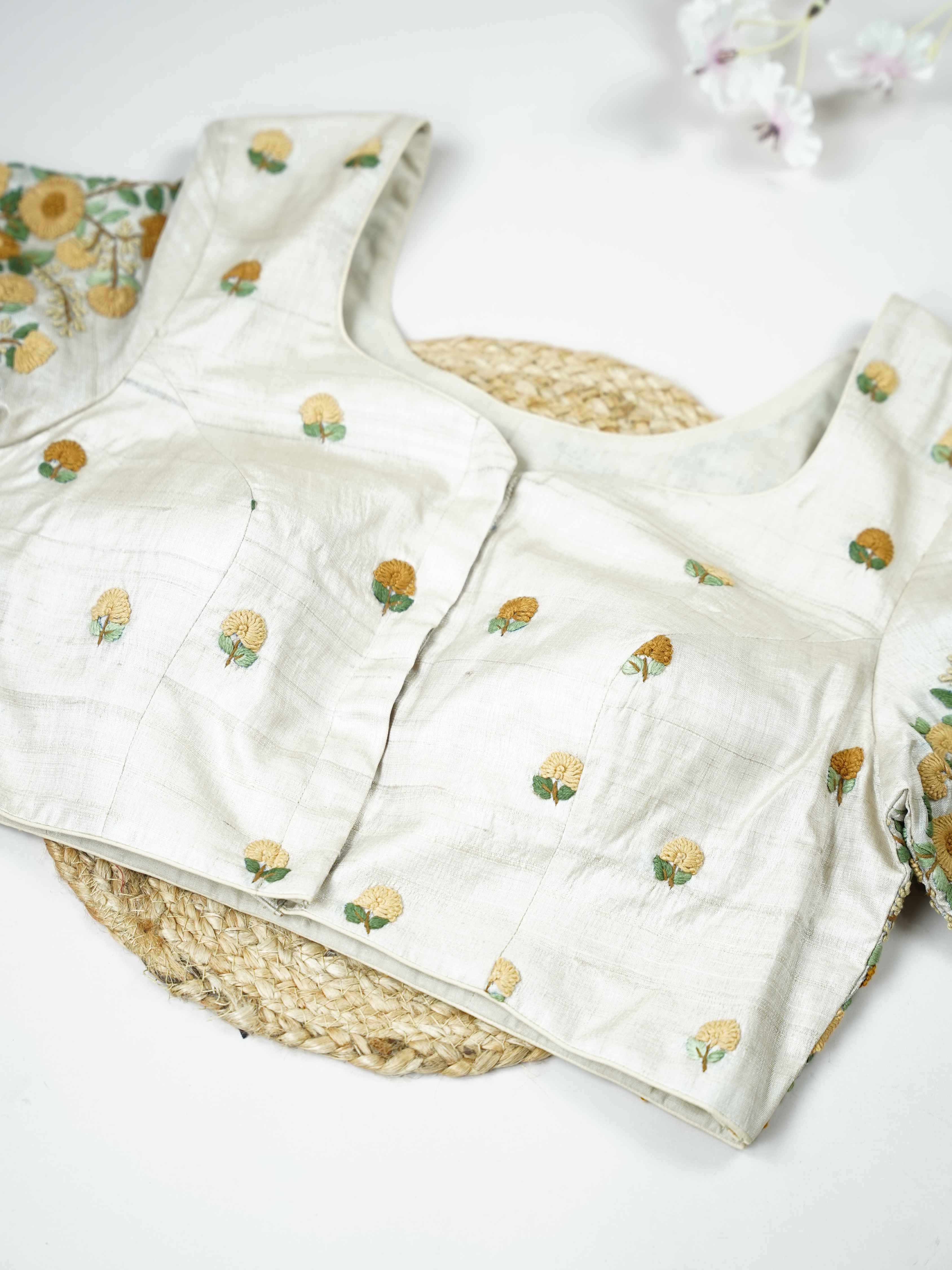 Tussar This elegant off-white Tussar blouse features finely stitched hand embroidery work.br data-start=83 data-end=86The front is delicately adorned with small floral motifs, adding a soft and graceful charm.br data-start=177 data-end=180The back is fully designed with rich embroidery, showcasing intricate handcrafted artistry.br data-start=271 data-end=274Perfect for ethnic wear, it creates a timeless, elegant, and beautifully balanced traditional look. Arohi - Tussar Silk Saree | Hand Embroidered - Manor