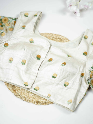 Tussar This elegant off-white Tussar blouse features finely stitched hand embroidery work.br data-start=83 data-end=86The front is delicately adorned with small floral motifs, adding a soft and graceful charm.br data-start=177 data-end=180The back is fully designed with rich embroidery, showcasing intricate handcrafted artistry.br data-start=271 data-end=274Perfect for ethnic wear, it creates a timeless, elegant, and beautifully balanced traditional look. Arohi - Tussar Silk Saree | Hand Embroidered - Manor