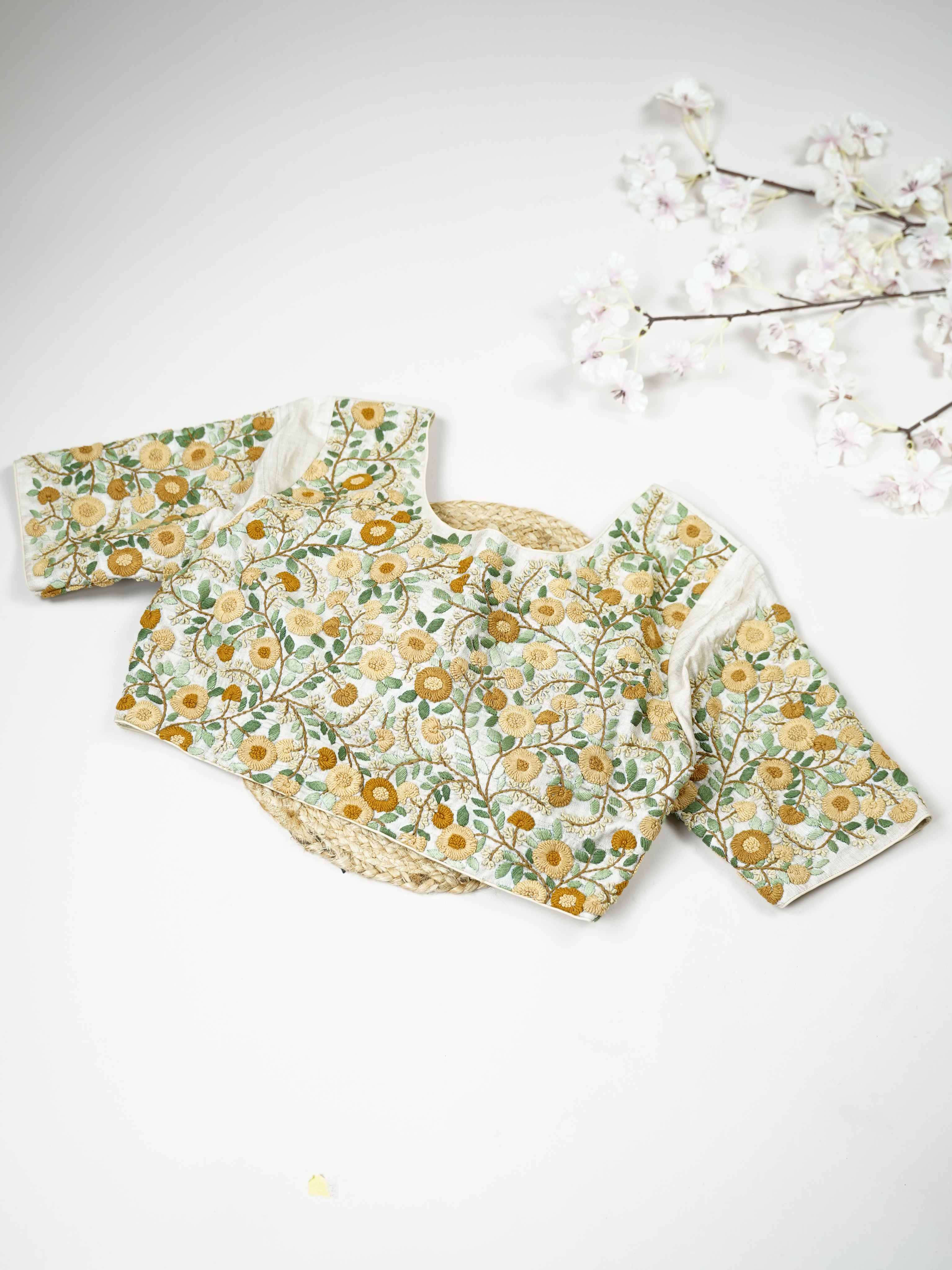 Tussar This elegant off-white Tussar blouse features finely stitched hand embroidery work.br data-start=83 data-end=86The front is delicately adorned with small floral motifs, adding a soft and graceful charm.br data-start=177 data-end=180The back is fully designed with rich embroidery, showcasing intricate handcrafted artistry.br data-start=271 data-end=274Perfect for ethnic wear, it creates a timeless, elegant, and beautifully balanced traditional look. Arohi - Tussar Silk Saree | Hand Embroidered - Manor
