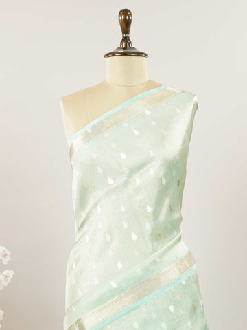 Tissue Step into subtle elegance with this tissue saree in a soothing powder green shade, paired with a matching blouse. The lightweight tissue fabric offers a soft, graceful shimmer that enhances its refined appeal. Delicate gold and silver buttas are woven throughout, adding a hint of festive charm and sophistication. Perfect for festive occasions, receptions, and elegant gatherings that call for understated beauty. Charukesi - Banarasi Tissue Kora Saree | Lightweight | Woven Buttas - Manoranjitham Weaves