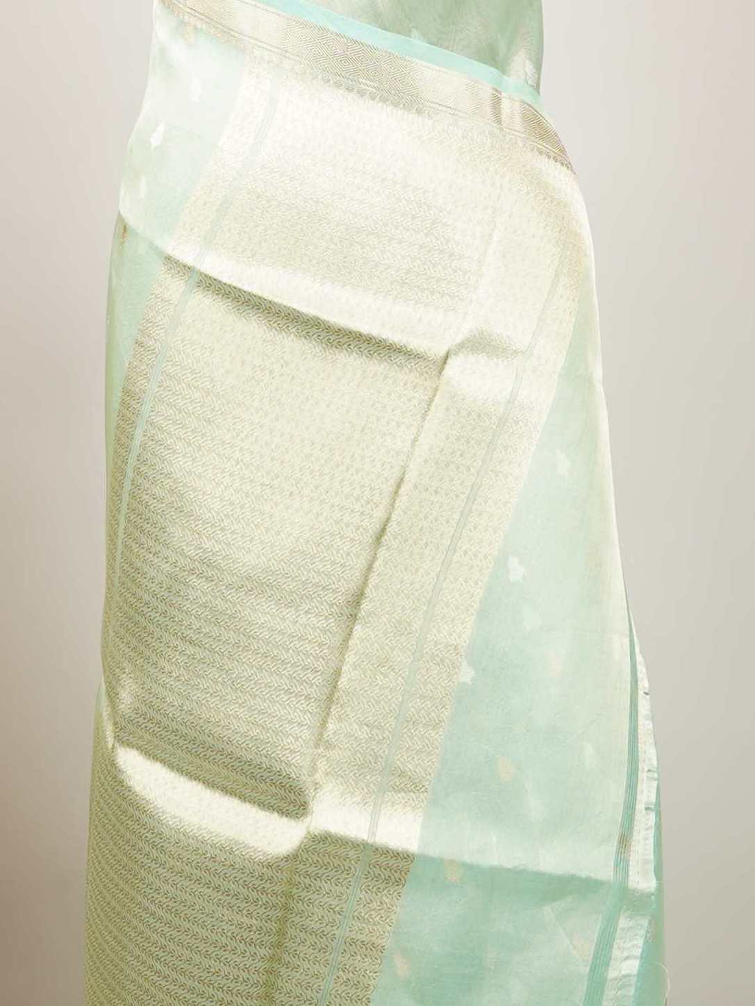 Tissue Step into subtle elegance with this tissue saree in a soothing powder green shade, paired with a matching blouse. The lightweight tissue fabric offers a soft, graceful shimmer that enhances its refined appeal. Delicate gold and silver buttas are woven throughout, adding a hint of festive charm and sophistication. Perfect for festive occasions, receptions, and elegant gatherings that call for understated beauty. Charukesi - Banarasi Tissue Kora Saree | Lightweight | Woven Buttas - Manoranjitham Weaves