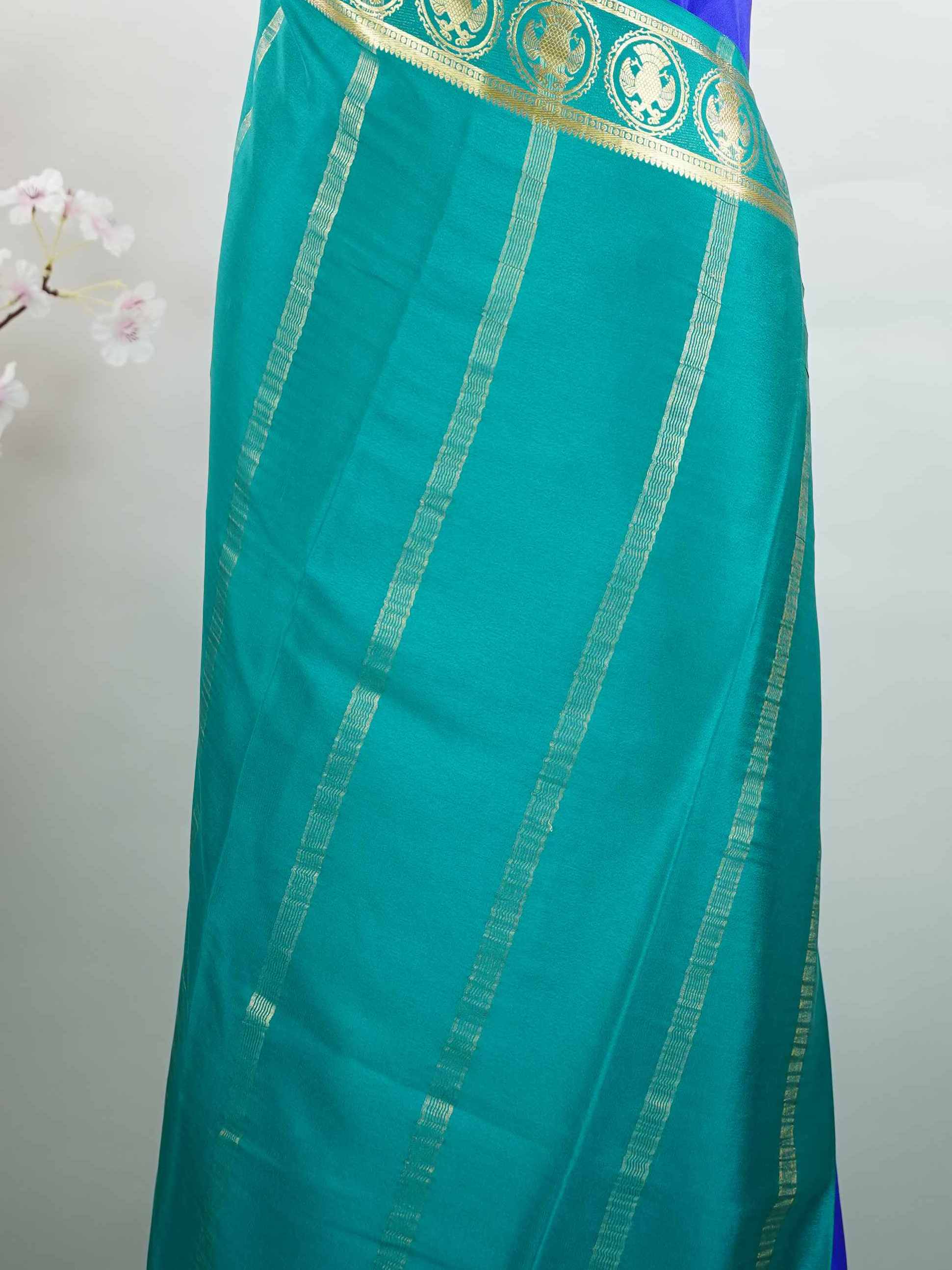 Mysore silk Rich blue Mysore silk featuring traditional checks and intricately woven Gandaberunda motifs across the body. A graceful Mysore silk saree crafted using pure handloom techniques. Its soft silk weave offers elegance with comfort. Simple styling adds timeless sophistication. Woven to reflect heritage and artistry. A beautiful saree for every occasion.brA graceful blend of heritage craftsmanship and timeless South Indian elegance. Tejomayi - Blue Pure Mysore Silk Saree | Gandaberunda Motifs - Manor