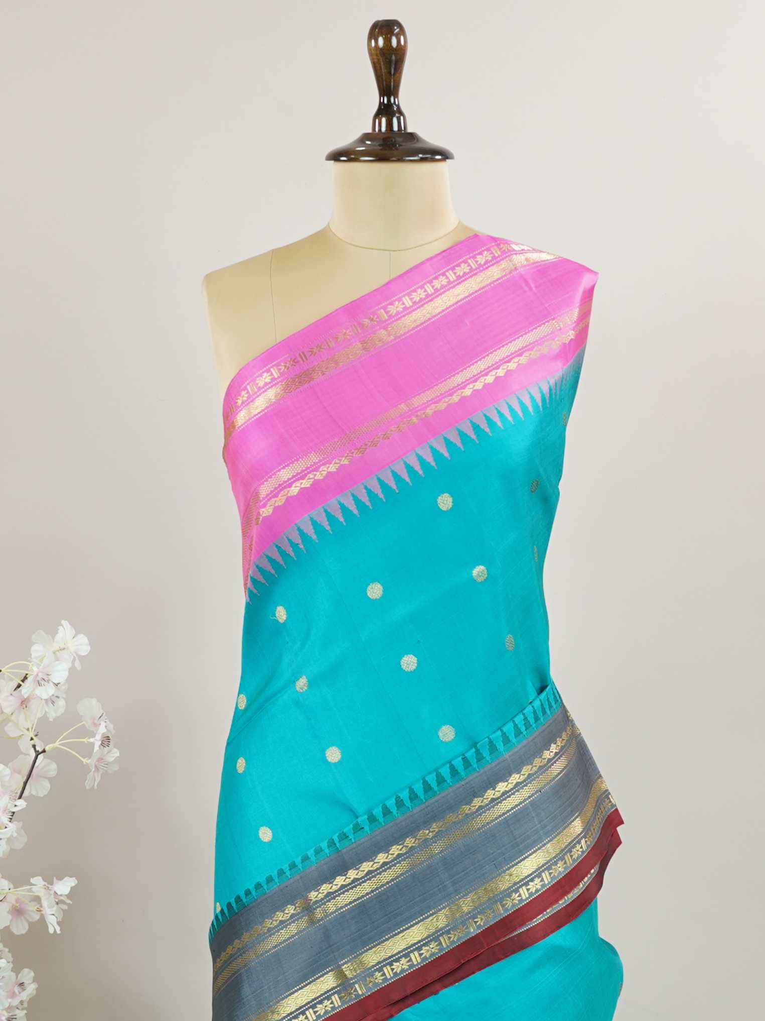 Gadwal Silk This Gadwal silk saree, adorned in Cyan and detailed with Pure Zari weaving, reflects the grandeur of Gadwal. The timeless Buttis motifs enhance its bridal charm. A perfect blend of luxury and tradition, it is designed for those who appreciate fine craftsmanship. Nattakurinji - Handloom Gadwal Silk Saree - Manoranjitham Weaves - Handloom Store