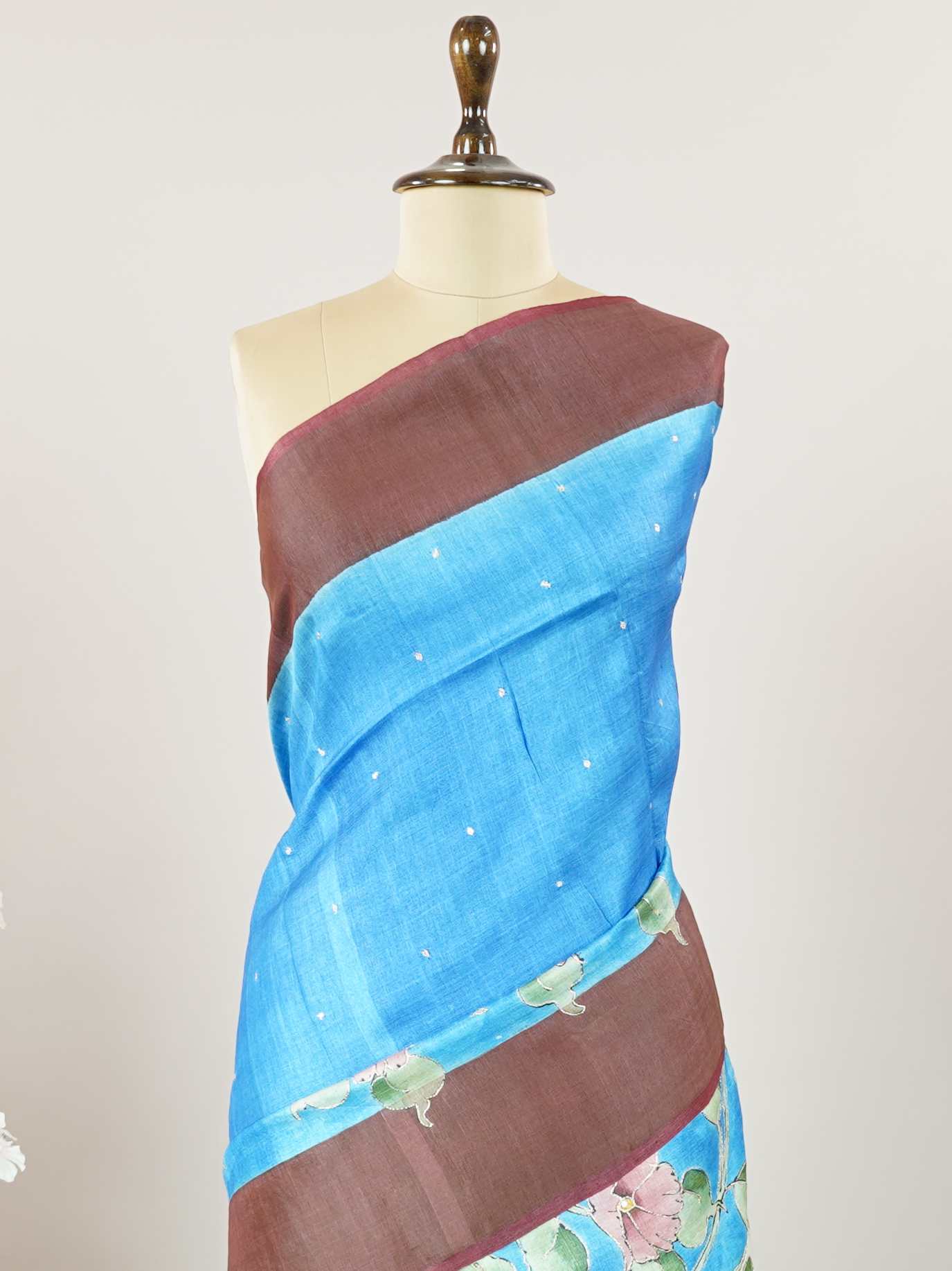 Tussars A Tussar saree with a plain upper body and digital print on the bottom border and pallu, enhanced with Aari Peeta embroidery for a subtle, handcrafted charm. Desha - Tussar Silk Saree | Digital Print - Manoranjitham Weaves - Handloom Store