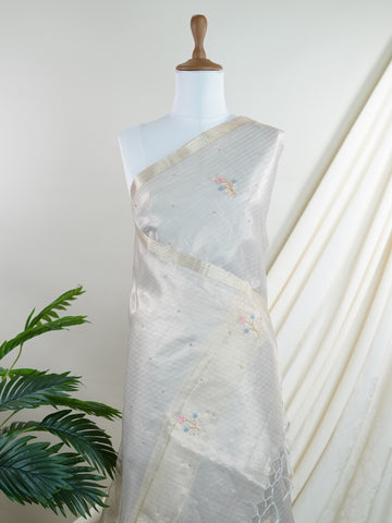 tissue This exquisite Silver Kora Tissue saree dazzles with delicate gold floral zari work, weaving elegance into every thread. Crafted on a powerloom in Varanasi, its lightweight texture shimmers beautifully, perfect for festive occasions or celebrations. The fine zari detailing adds a regal touch, blending tradition with contemporary charm. Wrap yourself in this graceful masterpiece and shine with timeless beauty. Padmalatha - Banarasi Tissue Kora Saree - Manoranjitham Weaves - Handloom Store