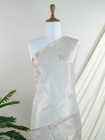 tissue This exquisite Silver Kora Tissue saree dazzles with delicate gold floral zari work, weaving elegance into every thread. Crafted on a powerloom in Varanasi, its lightweight texture shimmers beautifully, perfect for festive occasions or celebrations. The fine zari detailing adds a regal touch, blending tradition with contemporary charm. Wrap yourself in this graceful masterpiece and shine with timeless beauty. Padmalatha - Banarasi Tissue Kora Saree - Manoranjitham Weaves - Handloom Store