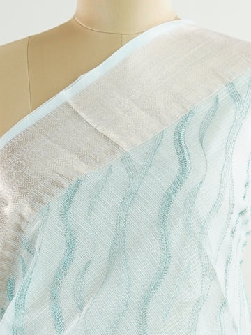 Kora This exquisite Light Blue Kora Tissue saree dazzles with delicate gold floral zari work, weaving elegance into every thread. Crafted on a powerloom in Varanasi, its lightweight texture shimmers beautifully, perfect for festive occasions or celebrations. The fine zari detailing adds a regal touch, blending tradition with contemporary charm. Wrap yourself in this graceful masterpiece and shine with timeless beauty. Nagagandhari - Manoranjitham Weaves - Handloom Store