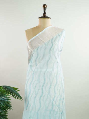 Kora This exquisite Light Blue Kora Tissue saree dazzles with delicate gold floral zari work, weaving elegance into every thread. Crafted on a powerloom in Varanasi, its lightweight texture shimmers beautifully, perfect for festive occasions or celebrations. The fine zari detailing adds a regal touch, blending tradition with contemporary charm. Wrap yourself in this graceful masterpiece and shine with timeless beauty. Nagagandhari - Manoranjitham Weaves - Handloom Store