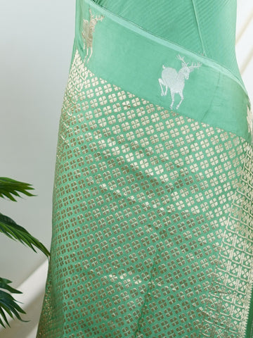 Mushru This Semi Mushru saree, woven on a powerloom in Varanasi, features elegant gold fine zari motifs that shimmer delicately across its fabric. The medium border adds a refined frame, enhancing its timeless appeal. It offers a perfect drape for festive and formal occasions, blending tradition with subtle luxury. Kalanemi - Semi Silk Saree - Manoranjitham Weaves - Handloom Store