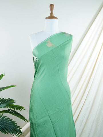 Mushru This Semi Mushru saree, woven on a powerloom in Varanasi, features elegant gold fine zari motifs that shimmer delicately across its fabric. The medium border adds a refined frame, enhancing its timeless appeal. It offers a perfect drape for festive and formal occasions, blending tradition with subtle luxury. Kalanemi - Semi Silk Saree - Manoranjitham Weaves - Handloom Store