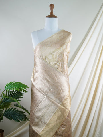 Katan A Tissue saree is the perfect blend of delicate silk and shimmering zari, woven to create an ethereal, translucent fabric that sparkles with every movement. Lightweight and luxurious, it’s ideal for grand occasions and celebrations where elegance is key. Draped in a Tissue saree, you embody timeless glamour with a modern twist. Avyaktha - Banarasi Tissue Kora Saree - Manoranjitham Weaves - Handloom Store