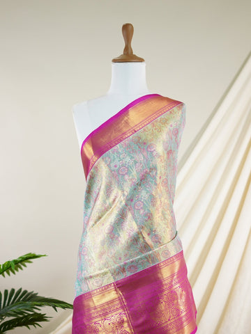 Kanchipuram Silk A sublime olive green Kanchipuram silk saree, gracefully adorned with gold and silver zari buttas, reflecting timeless artistry. The vibrant pink border lends a striking contrast, perfect for festive occasions and weddings. Woven from 100% pure silk, this saree radiates heritage and elegance in every thread.Its luxurious texture and intricate zari work make it a cherished piece for your trousseau or special celebrations.          #ManoranjithamSilks #KanjivaramHandloom #PureSilkSaree #Brida