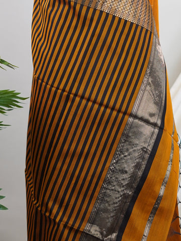 Maheshwari Handwoven by skilled artisans of Surat, this Semi Silk saree in Golden Brown blends traditional elegance with intricate nan zari work. A truly stunning drape for special occasions. The interplay of colors and craftsmanship makes it a treasured piece for every saree connoisseur. Darbari - Golden Brown Semi Silk Saree - Manoranjitham Weaves - Handloom Store