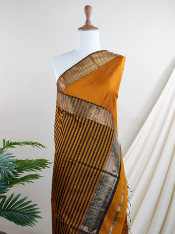 Maheshwari Handwoven by skilled artisans of Surat, this Semi Silk saree in Golden Brown blends traditional elegance with intricate nan zari work. A truly stunning drape for special occasions. The interplay of colors and craftsmanship makes it a treasured piece for every saree connoisseur. Darbari - Golden Brown Semi Silk Saree - Manoranjitham Weaves - Handloom Store