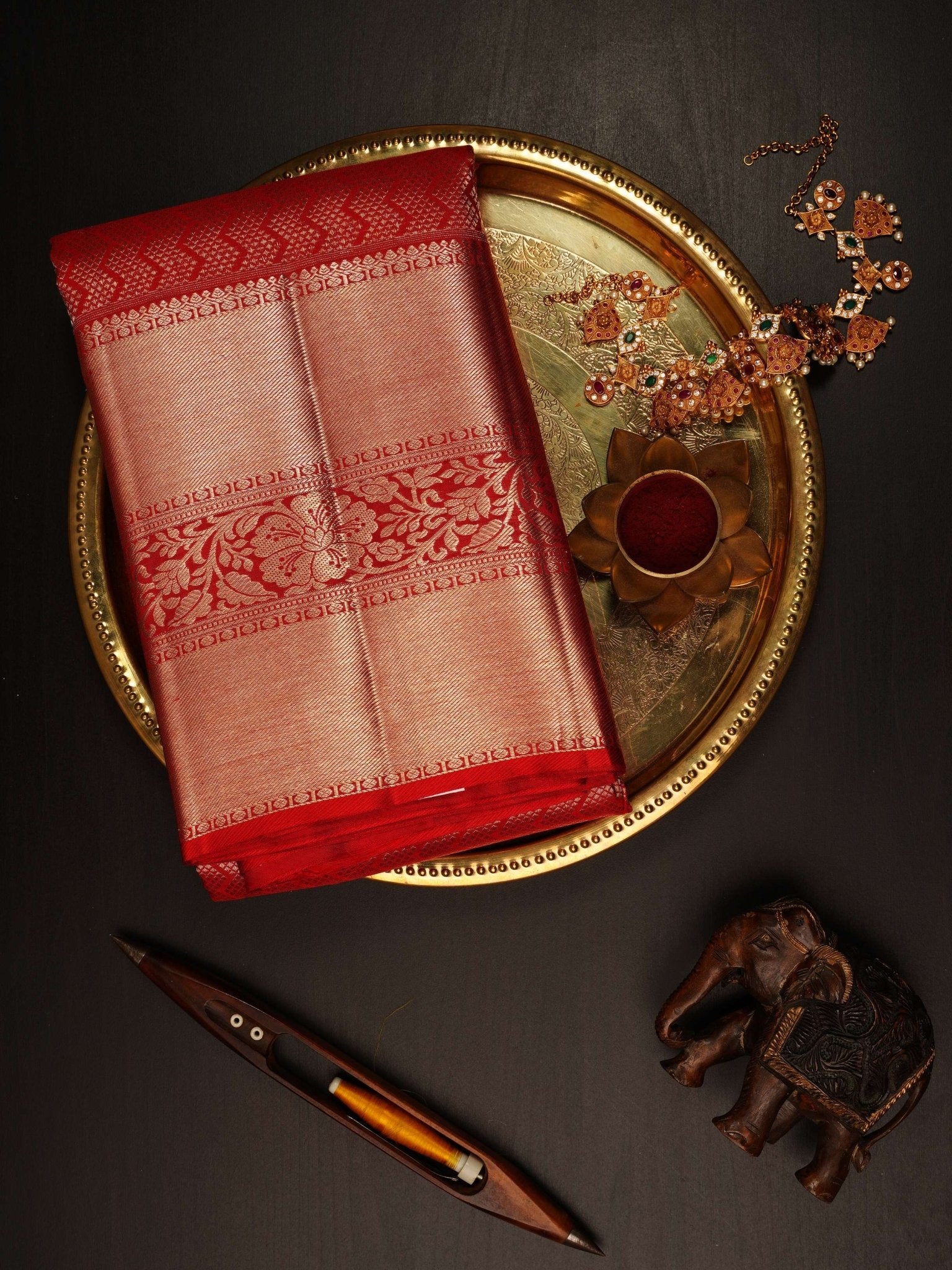 Kanchipuram Silk This 100% Pure Silk  silk saree, adorned in Red and detailed with Pure Zari weaving, reflects the grandeur of Maharashtra. The timeless Buttis motifs enhance its bridal charm. A perfect blend of luxury and tradition, it is designed for those who appreciate fine craftsmanship. Hemanta - Manoranjitham Weaves - Handloom Store