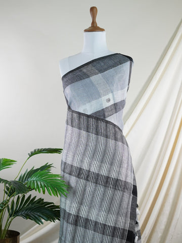 Linen A masterpiece from Rajasthan, this Linen saree in Black is a tribute to India's rich handloom legacy. The Semi Pure Zari weaving and Work motifs make it a perfect choice for brides and celebrations. Every thread speaks of elegance, tradition, and the skilled hands that bring this saree to life. Jogiya - Black Handloom Cotton Saree - Manoranjitham Weaves - Handloom Store