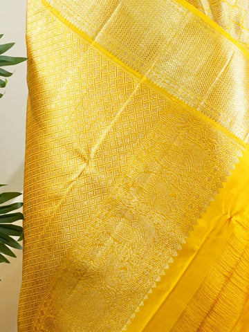 Kanchipuram Silk A masterpiece from Maharashtra, this 100% Pure Silk  saree in Golden Yellow is a tribute to India's rich handloom legacy. The Pure Zari weaving and Buttis motifs make it a perfect choice for brides and celebrations. Every thread speaks of elegance, tradition, and the skilled hands that bring this saree to life. Jogiya - Pure Kanjivaram Silk Saree - Manoranjitham Weaves - Handloom Store