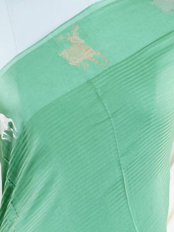 Mushru This Semi Mushru saree, woven on a powerloom in Varanasi, features elegant gold fine zari motifs that shimmer delicately across its fabric. The medium border adds a refined frame, enhancing its timeless appeal. It offers a perfect drape for festive and formal occasions, blending tradition with subtle luxury. Kalanemi - Semi Silk Saree - Manoranjitham Weaves - Handloom Store