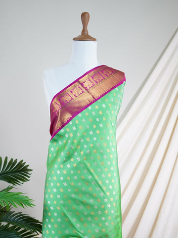 Kanchipuram Silk A masterpiece from Kanchipuram, this Kanjivaram saree in Lime Tree Green is a tribute to India's rich handloom legacy. The Pure Zari weaving and Buttis motifs make it a perfect choice for brides and celebrations. Every thread speaks of elegance, tradition, and the skilled hands that bring this saree to life. Nattakurinji - Manoranjitham Weaves - Handloom Store