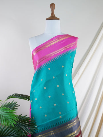Gadwal Silk This Gadwal silk saree, adorned in Cyan and detailed with Pure Zari weaving, reflects the grandeur of Gadwal. The timeless Buttis motifs enhance its bridal charm. A perfect blend of luxury and tradition, it is designed for those who appreciate fine craftsmanship. Nattakurinji - Manoranjitham Weaves - Handloom Store
