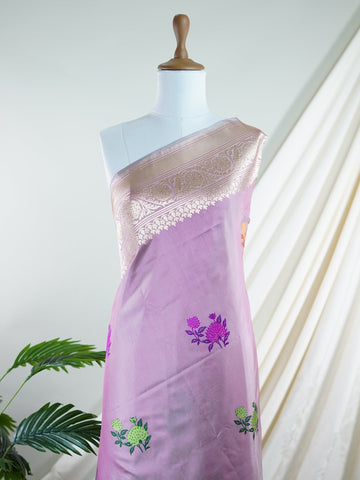 Katan An exquisite creation from Varanasi, this glass tissue saree is adorned with delicate embroidery and refined ari pita work. Its sheer texture catches the light with every fold, while the intricate detailing adds depth and artistry. A luminous drape for occasions steeped in grace and tradition. Padmini - Manoranjitham Weaves - Handloom Store