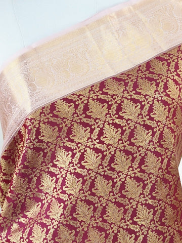 Kanchipuram Silk Beautiful bridal Kanjivaram saree adorned with a rich Butter Burgundy body, elegantly paired with a Pastel Pink border, pallu, and matching blouse. Lavishly woven with all-over gold and silver tissue, adding a regal shimmer and luxurious appeal to the ensemble. The striking blend of deep Burgundy and soft Pastel Pink creates a graceful balance of grandeur and femininity. A timeless bridal drape that celebrates exquisite craftsmanship, making it perfect for weddings and cherished occasions. 