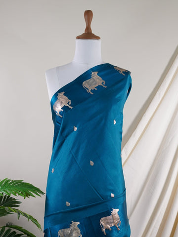 Katan A masterpiece from Varanasi, this Banarasi Katan saree in Dark Teal is a tribute to India's rich handloom legacy. The Tested Zari weaving and Motifs motifs make it a perfect choice for brides and celebrations. Every thread speaks of elegance, tradition, and the skilled hands that bring this saree to life. Sohinia - Banarasi Katan Silk Saree | Woven Motifs - Manoranjitham Weaves - Handloom Store