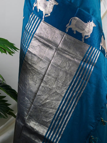 Katan A masterpiece from Varanasi, this Banarasi Katan saree in Dark Teal is a tribute to India's rich handloom legacy. The Tested Zari weaving and Motifs motifs make it a perfect choice for brides and celebrations. Every thread speaks of elegance, tradition, and the skilled hands that bring this saree to life. Sohinia - Banarasi Katan Silk Saree | Woven Motifs - Manoranjitham Weaves - Handloom Store
